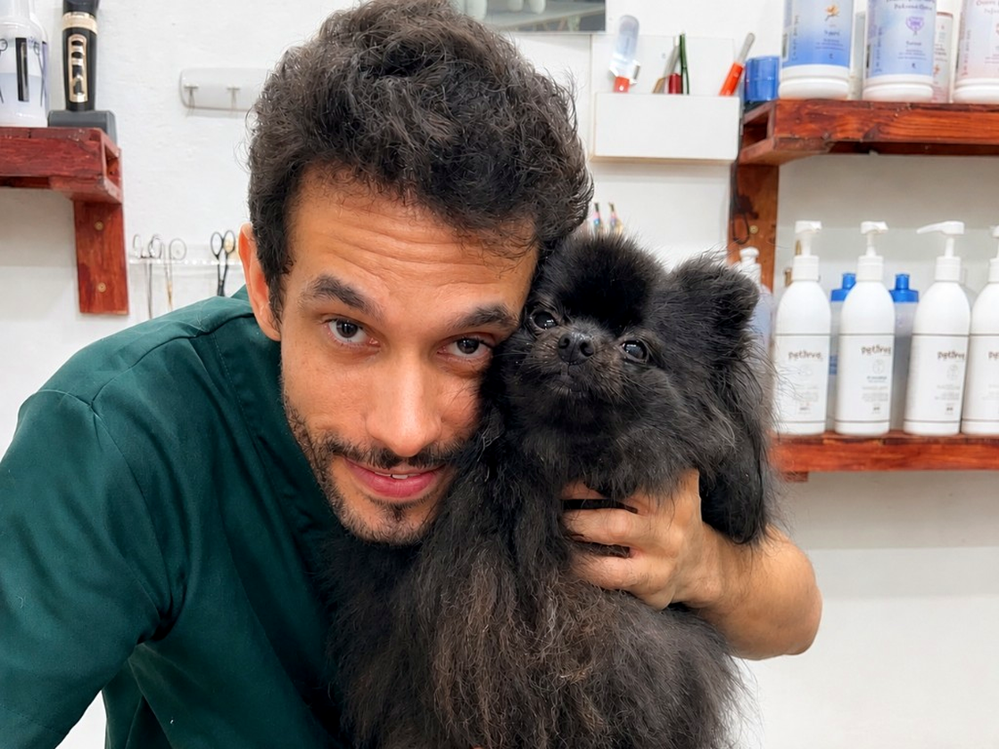 Profissional do Charme Canino com pet preto no salão